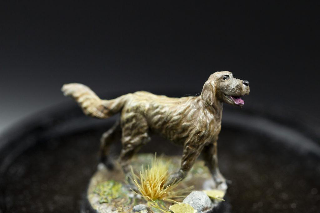 Photo of printed 3d miniature dog. His fur became highlighted over drybrushing.