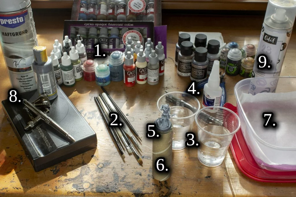 All items needed to paint your 3d miniatures or sculptures. Paints, washes, brushes, two cups of water, clippers, superglue, handle, waterpad, spray primer and varnish.