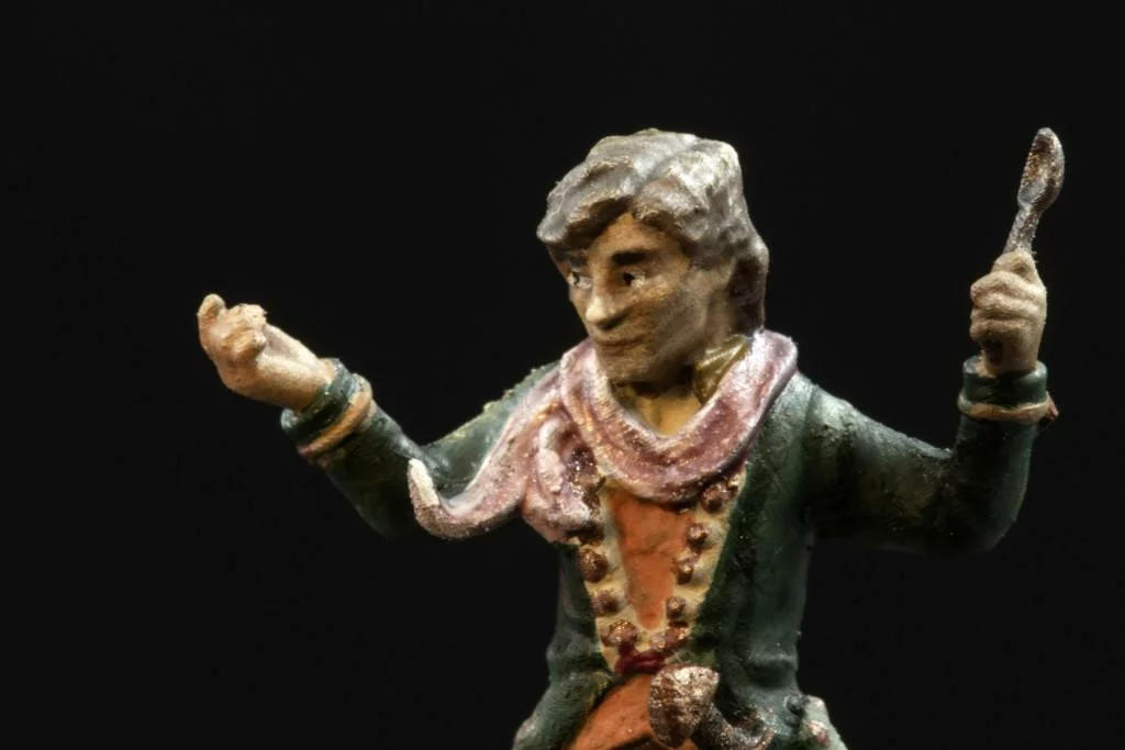 Details showed on an example of halfling 3d miniature. He holds a tiny spoon in hand, has a lot of buttons in the coat.